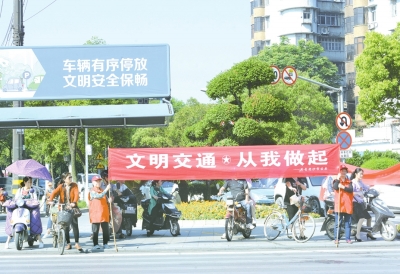 图文:荆州老姨妈拉横幅标语 劝导市民文明过马